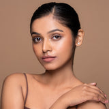 A person with a medium skin tone wearing a matte brown lipcolor.