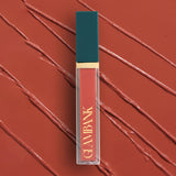 Lipstick with teal cap and gold accent on a red background