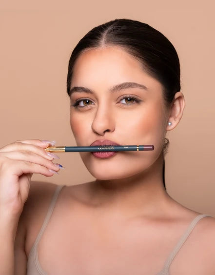  Woman holding a makeup pencil against a beige background 