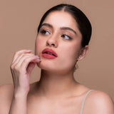 Woman with pink lipstick posing against a beige background